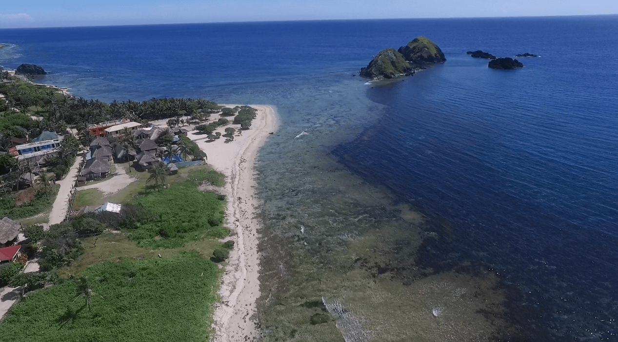 Blue Lagoon Beach in Pagudpud Ilocos Norte as seen from the sky by drone footage.