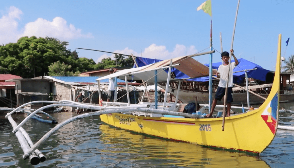 Yellow boat in the philippines with filipino boat boy