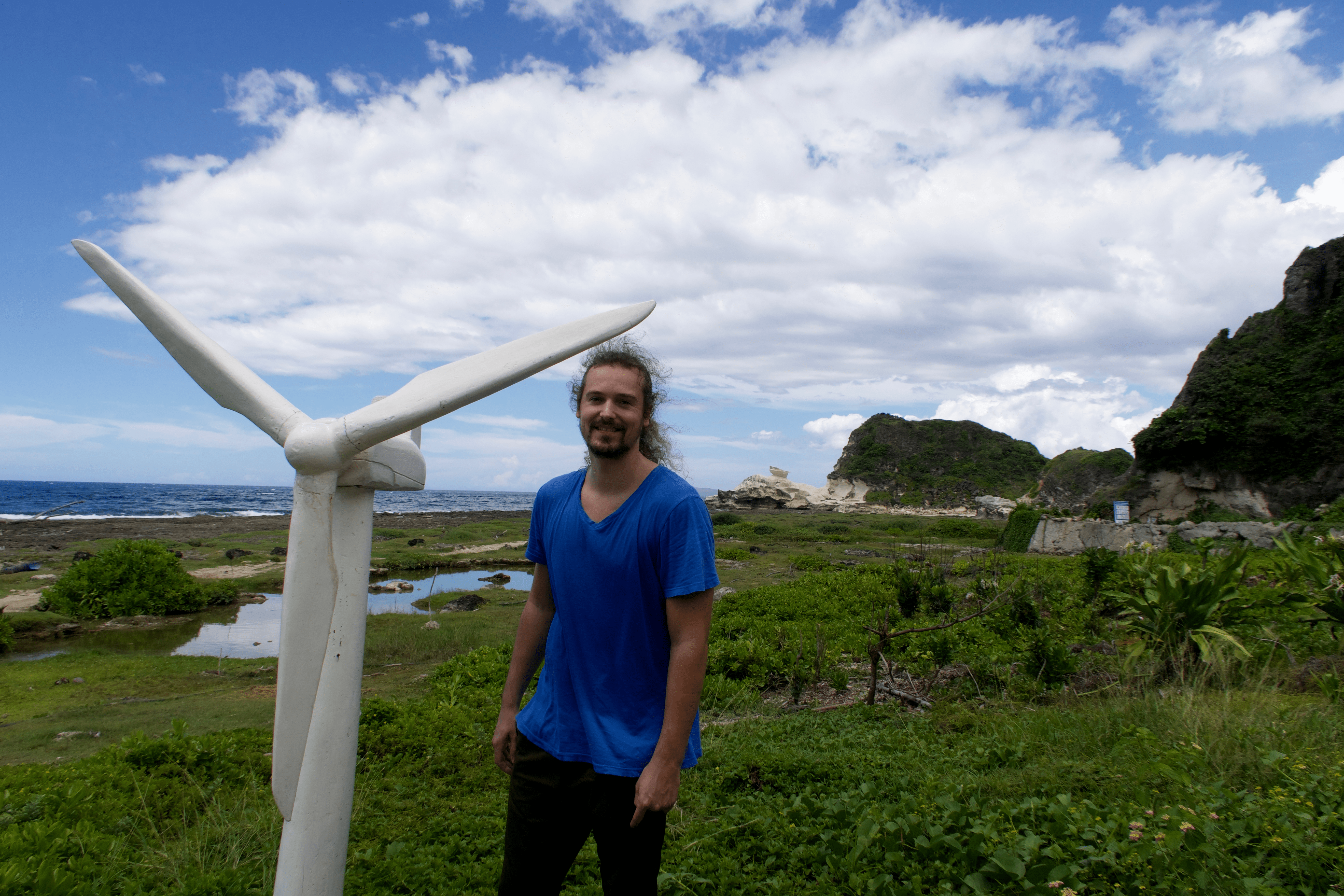 Lenny Through Paradise posing with a mini windmill with the Kapurpurawan rock formation in the background. Pagudpud, Ilocos Norte, Philippines.