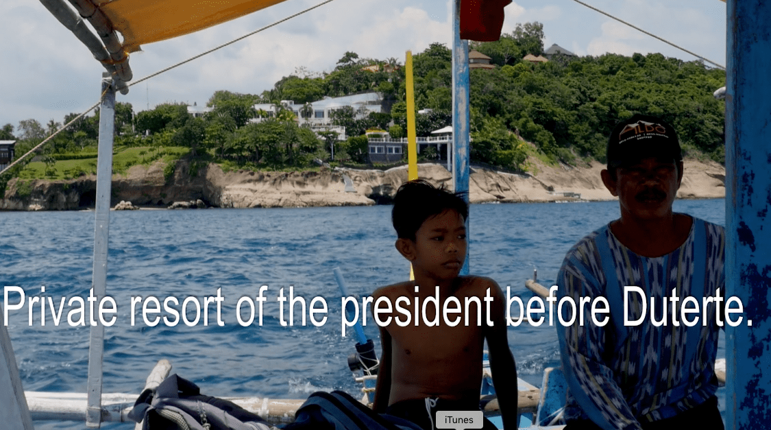 Filipino boatmen in Batangas, with the private resort of a former president in the Philippines