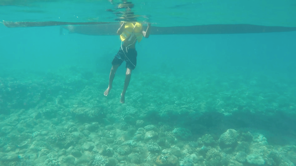 Beautiful underwater sight in the philippines with boat and boy