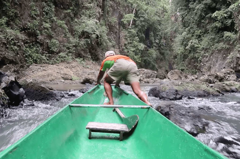 boatmen pusing canoe through river stream upwards to the pagsanjan falls laguna philippines
