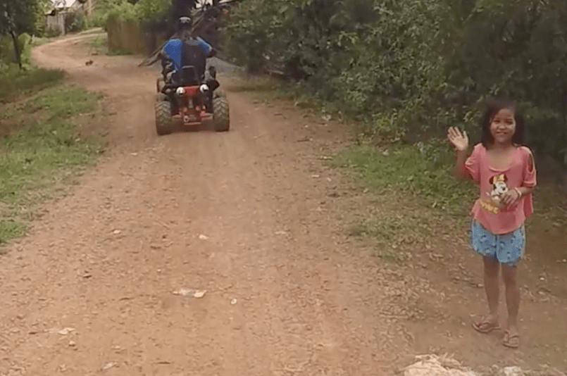 little filipina girl waving to quad riders