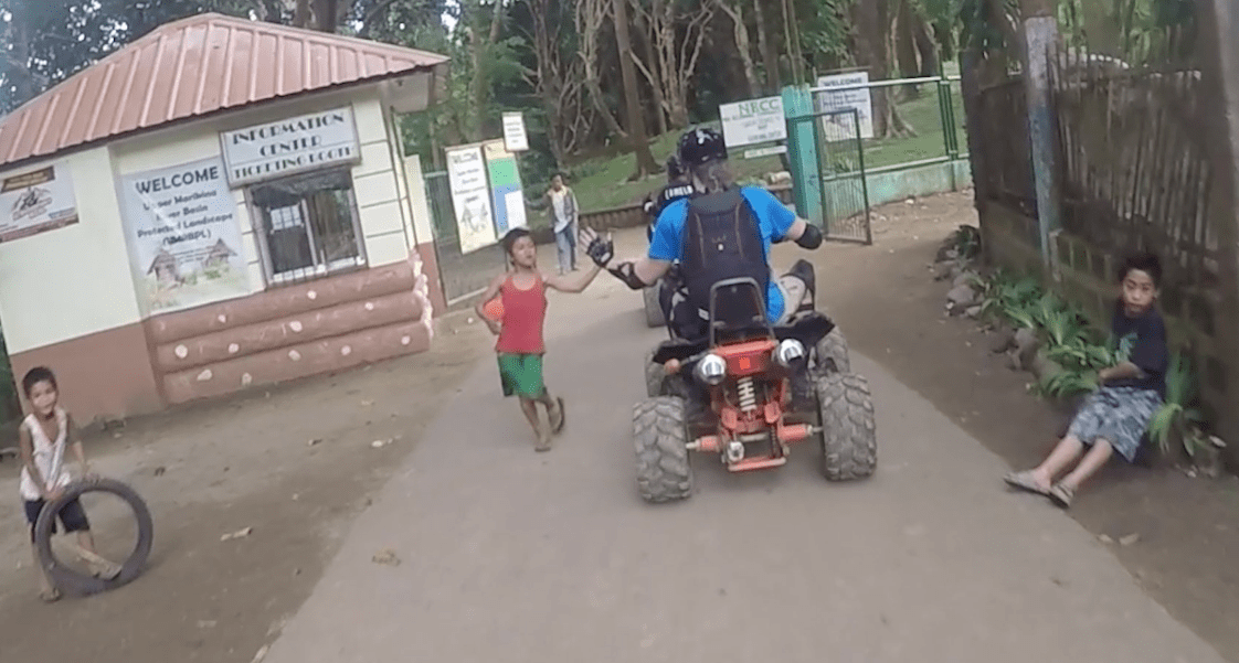 high five with local filipino kid while quad riding